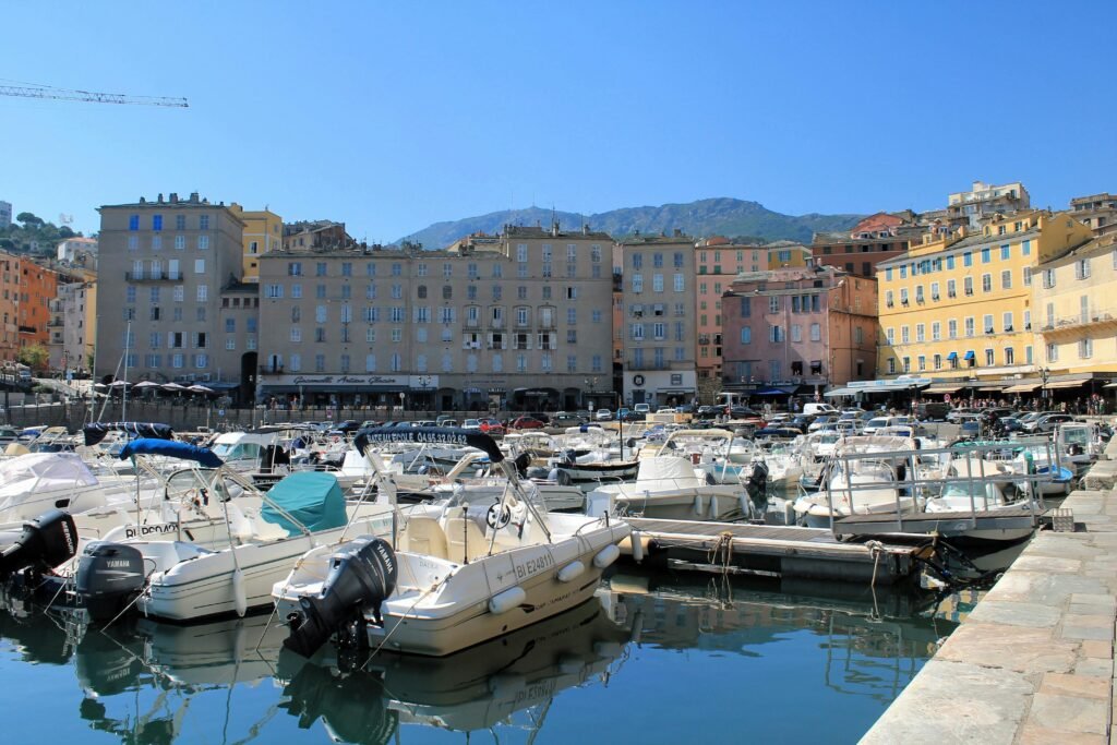 Harbor in Corsica with boats and historic buildings, one of the best places to travel in September