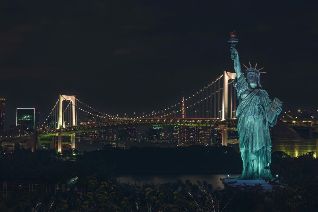 Japan Itinerary Day: Odaiba's Statue of Liberty with Tokyo's Rainbow Bridge illuminated at night