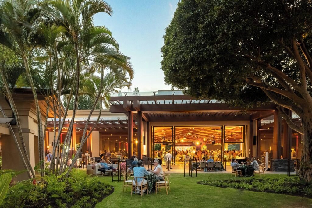 The Ritz-Carlton, Kapalua-Outdoor dining area with open-air restaurant surrounded by lush greenery.