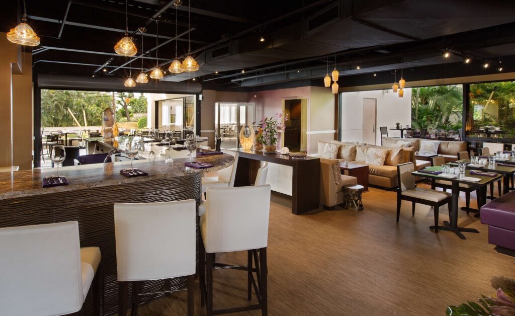 Maui Coast Hotel-Stylish restaurant interior with bar seating and dining tables